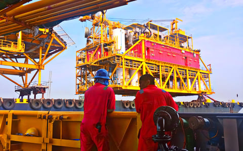 Offshore worker performing maintenance on oil platform at sea